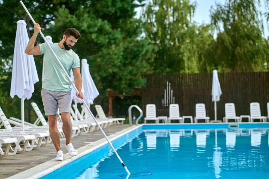 a-service-person-cleaning-the-swimming-pool-and-looking-busy